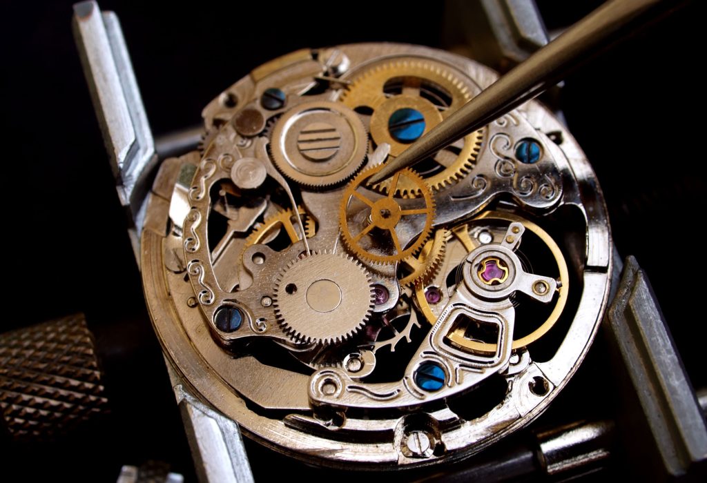 Watch battery replacement at the Alpha Group workshop, with the inside of the watch visible